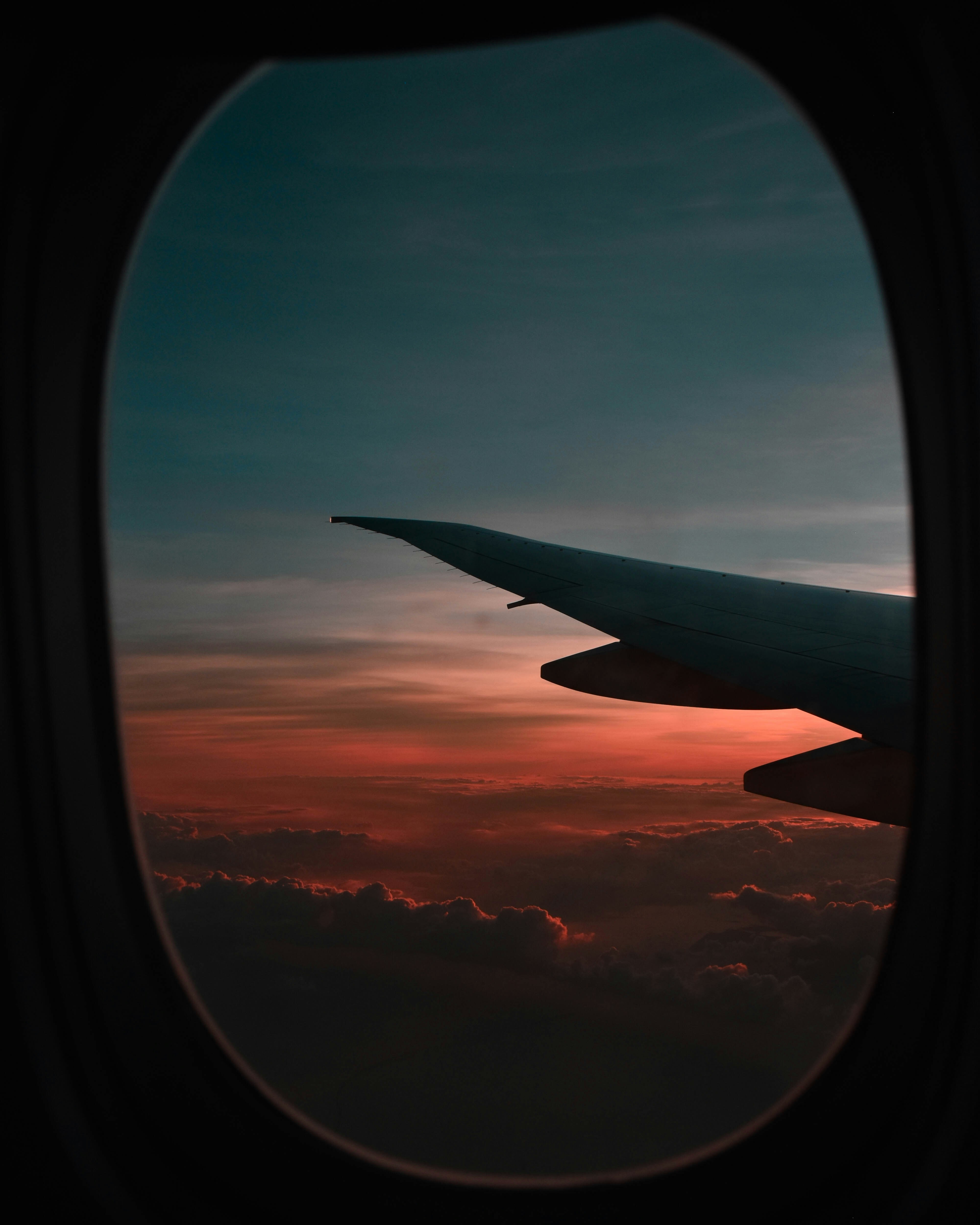 Aircraft wing view through cabin window at sunset